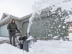 Clint Domansky clears thick heavy snow from his driveway with a snowblower in the Chaparral neighbourhood of Calgary on Tuesday, April 30, 2024.