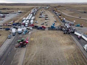 Anti-mandate demonstrators gather as a truck convoy blocks the highway at the busy U.S. border crossing in Coutts, Alta., Monday, Jan. 31, 2022.