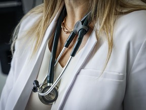 The Canadian Medical Association is asking the federal government to reconsider its proposed changes to capital gains taxation, arguing it will affect doctors' retirement savings. A doctor wears a lab coat and stethoscope in an exam room at a health clinic in Calgary, Alta., Friday, July 14, 2023.