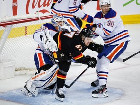 Edmonton Oilers forward Corey Perry (90) checks Calgary Flames forward Connor Zary (47) into goalie Calvin Pickard (30) during first period NHL hockey action in Calgary