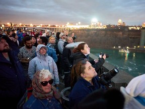 People watch the sky during the total solar eclipse, in Niagara Falls, Ont., on April 8, 2024.