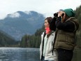 Francisca Barros, left, and Ivisa Simunovic, visiting from Vancouver, spot the orphaned orca calf who has been stranded since its pregnant mother died after being caught when the tide went out more than a week ago in a lagoon near Zeballos, B.C., on Monday, April 1, 2024.