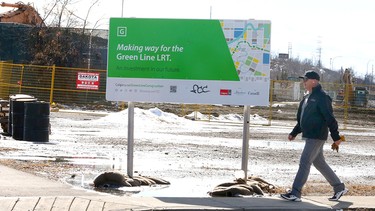 A pedestrian walks by as demolition and construction continues for the Green Line LRT at the site of the former Lilydale Chicken plant in the Ramsay neighbourhood in southeast Calgary on Tuesday, March 12, 2024.