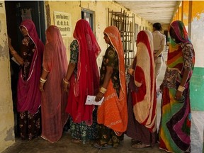 Women stand in a queue outside a polling station to cast their ballot during the first phase of voting for the India's general elections in Parbatsar in Rajasthan, on April 19, 2024.