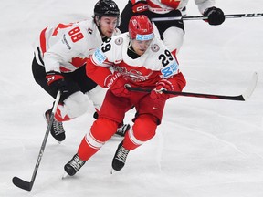 Canada's forward Andrew Mangiapane vies for a puck with Denmark's forward Mikkel Aagaard.