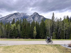 An image of two people cycling along the trail to Sundance Canyon in Banff National Park in Alberta, Canada.