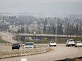 Traffic moves along Alberta Highway 63 as wildfire smoke hangs in air in Fort McMurray, Alta., Wednesday, May 15, 2024.