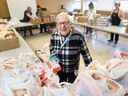 Volunteer Dorothy Bagan stands among bags of groceries to be distributed by the weekly bread market at the Kerby Centre in Calgary.