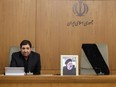 A handout picture released by the Iranian presidency shows Iran's First Vice President Mohammad Mokhber, with the seat of the late president Ebrahim Raisi (portrait) next to him empty, addressing the country's cabinet in Tehran on May 20, 2024.