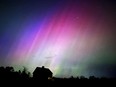 The northern lights flare in the sky over a farmhouse, late Friday, May 10, 2024, in Brunswick, Maine. Brilliant purple, green, yellow and pink hues of the Northern Lights were reported worldwide, with sightings in Germany, Switzerland, London, and the United States and Canada.