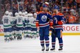 Mattias Ekholm #14 and Evan Bouchard #2 of the Edmonton Oilers skate off the ice after a loss to the Vancouver Canucks in Game Three of the Second Round of the 2024 Stanley Cup Playoffs at Rogers Place on May 12, 2024 in Edmonton, Alberta.