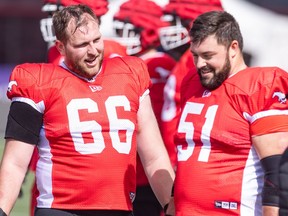 Calgary Stampeders offensive linemen Bryce Bell, left, and Sean McEwen chat on the sidelines during practice at McMahon Stadium on Thursday,