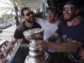 From left, Florida Panthers' Anthony Stolarz, Sam Bennett and Matthew Tkachuk sing "We Are The Champions" as they celebrate winning the the Stanley Cup.