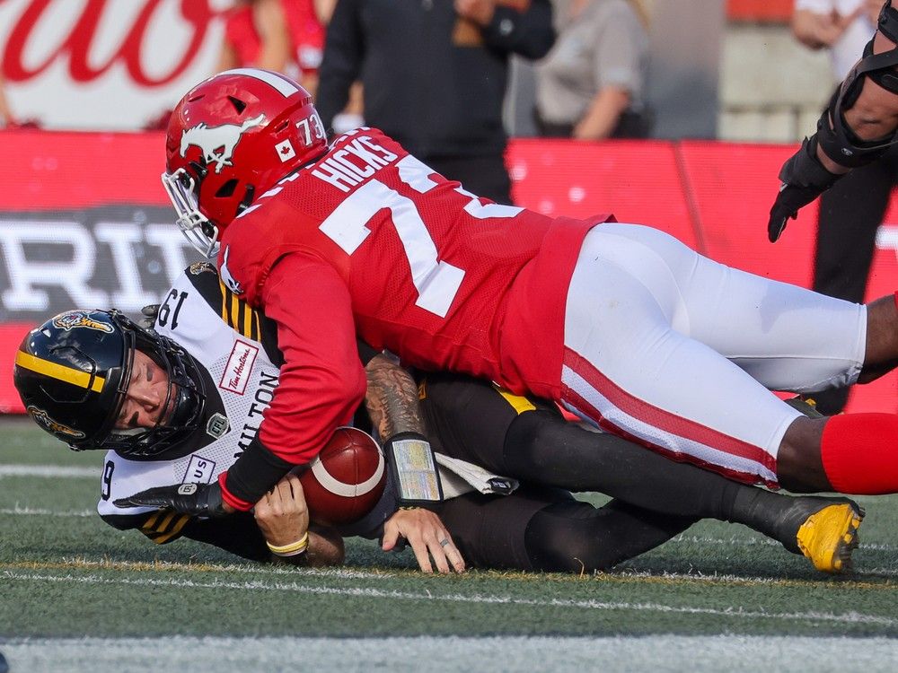 Calgary Stampeders defensive lineman Clarence Hicks sacks Hamilton Tiger-Cats quarterback Bo Levi Mitchell at McMahon Stadium in Calgary on Friday, June 7, 2024. 