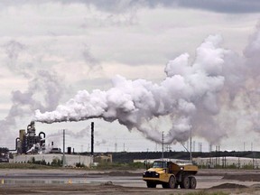 Canadian oil and gas companies facing a federally imposed emissions cap will cut their production rather than invest in emissions-reducing carbon capture and storage technology, a new report by Deloitte says. A dump truck works near an oil sands extraction facility near Fort McMurray, Alta. on Sunday June 1, 2014.