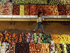 A shopper walks through a produce aisle at a grocery store in Toronto.