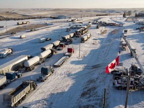 A truck convoy of anti-COVID-19 vaccine mandate demonstrators block the highway at the busy Canada-U.S. border crossing in Coutts, Alta., Wednesday, Feb. 2, 2022.