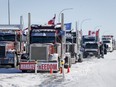 A truck convoy of anti-COVID-19 vaccine mandate demonstrators block the highway at the busy U.S. border crossing in Coutts, Alta., Wednesday, Feb. 2, 2022. The trial of two men charged with conspiracy to commit murder at the 2022 blockade at Coutts, Alta., resumes today.