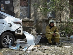 A rescuer rests next to a destroyed residential building following a missile attack in Lugansk, Russian-controlled Ukraine, on June 7, 2024.