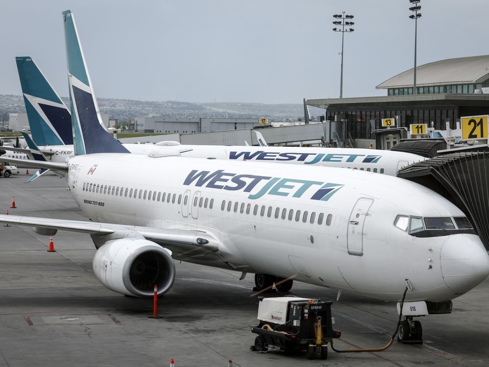 WestJet passenger jets arec shown parked at departure gates at the Calgary International Airport on Wednesday, May 31, 2023. WestJet says it faces a possible strike by its mechanics starting as early as Friday.THE CANADIAN PRESS/Jeff McIntosh