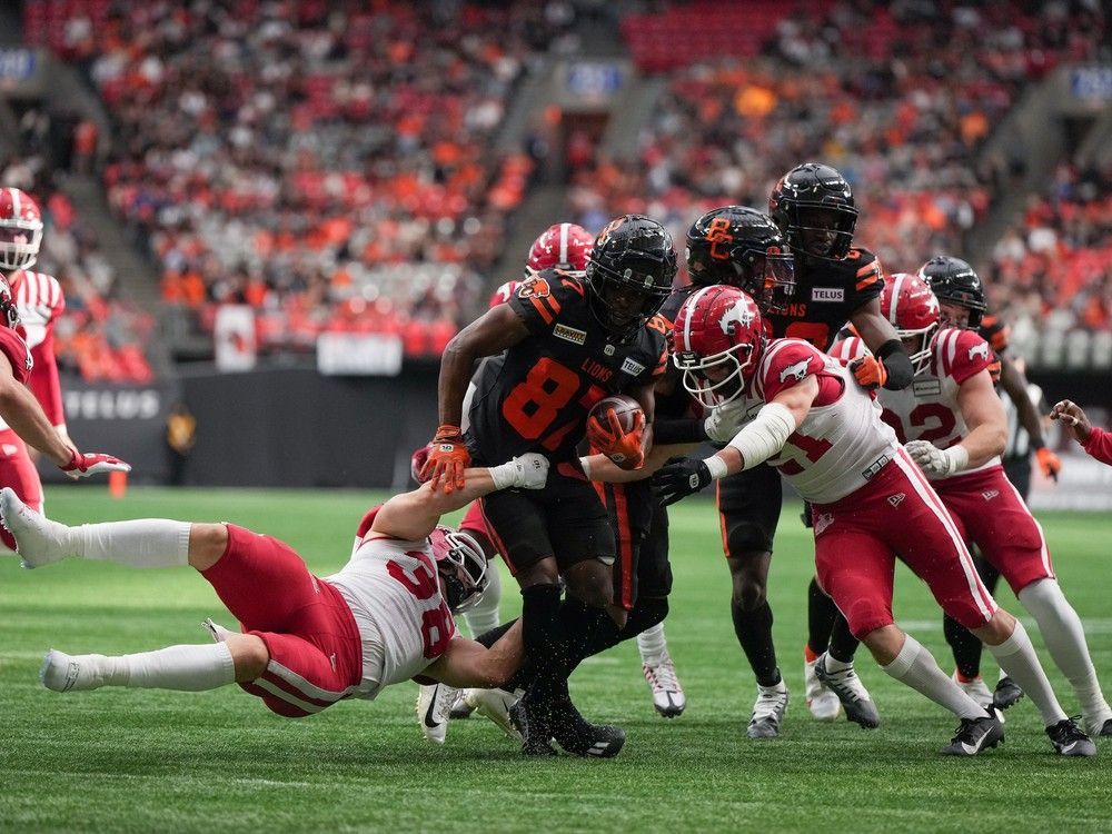 B.C. Lions' Terry Williams (87) is tackled by Calgary Stampeders' Adam Konar (38) during the second half of a CFL football game, in Vancouver, on Saturday, June 15, 2024.
