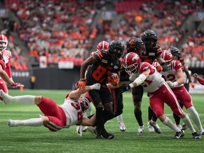 B.C. Lions' Terry Williams (87) is tackled by Calgary Stampeders' Adam Konar (38) during the second half of a CFL football game, in Vancouver