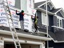 Workers replace siding on a row of hail-damaged homes in the northeast community of Redstone on Wednesday.