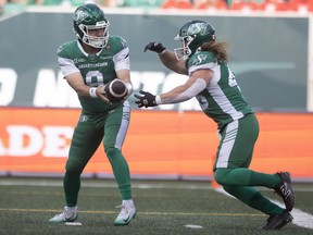 Saskatchewan Roughriders quarterback Jake Maier (9) hands the ball to Saskatchewan Roughriders running back A.J. Ouellette