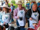 A trio of premiers, Alberta Premier Danielle Smith, Saskatchewan Premier Scott Moe and Ontario Premier Doug Ford work in the serving line at the annual Premier's Stampede Breakfast at McDougall Centre in Calgary on Monday, July 7, 2025.