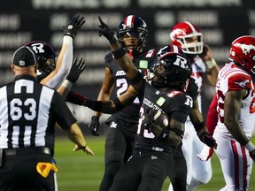 Deandre Lamont (middle) of the Ottawa Redblacks celebrates after intercepting a pass by the Calgary Stampeders in the first half of a Canadian Football League game at Ottawa on Thursday