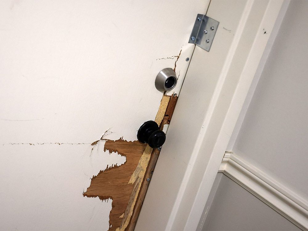  The damaged apartment door of a woman whose neigbhour tunnelled into her unit in a building in Coach Hill.