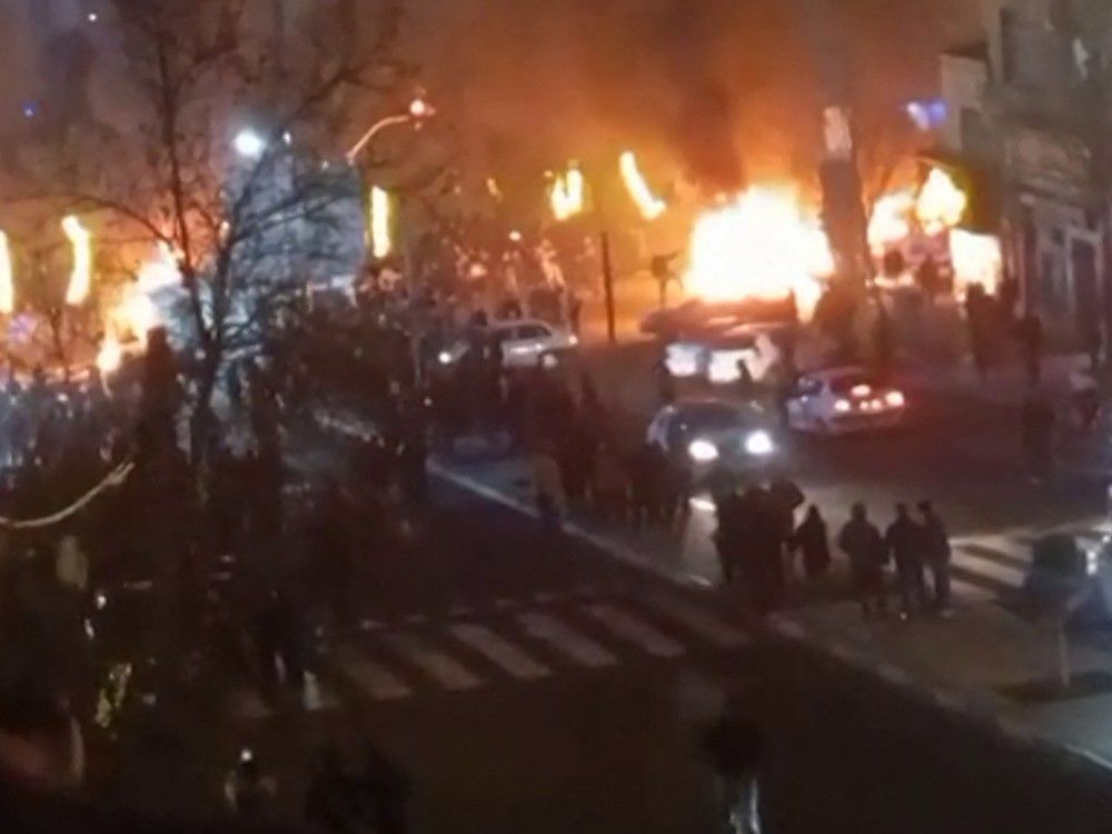 This video grab taken on Jan. 14, 2026 from UGC images posted on social media on Jan. 9, 2026 shows cars set on fire during a protest on Saadat Abad Square in Tehran.