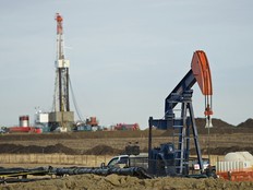 A pumpjack and drilling rig in Alberta