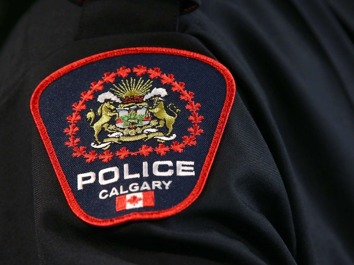 Calgary police charge two men in relation to a hate crime which left a woman trapped in a portable bathroom in the city's southwest.