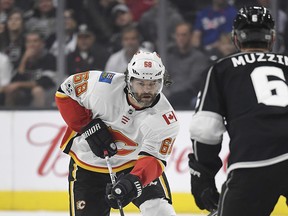 Calgary Flames right wing Jaromir Jagr, left, of the Czech Republic, moves the puck as Los Angeles Kings defenseman Jake Muzzin defends during the third period of an NHL hockey game, Wednesday, Oct. 11, 2017, in Los Angeles. The Flames won 4-3 in overtime.