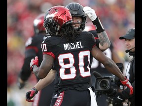Calgary Stampeders quarterback Bo Levi Mitchell, right, celebrates Marken Michel touchdown during their game against the Edmonton Eskimos during CFL Western Final action at McMahon Stadium in Calgary, Alta.. on Sunday November 19, 2017. Leah hennel/Postmedia