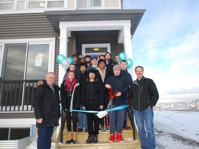 Courtesy Homes by Avi 
Homes by Avi founder Avi Amir, left, stands with a class from Jack James High School that worked on a  portion of the completed home behind them.