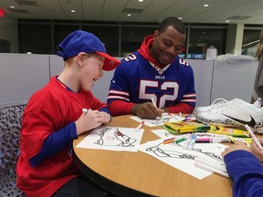 Buffalo Bills linebacker Preston Brown is joined by Will Lucas, left, in helping design customized cleats at Buffalo's John R. Oishei Children's Hospital on Tuesday, Nov. 14, 2017. Brown will be one of three players to wear the customized cleats during Buffalo's home game against the New England Patriots on Dec. 3. The event was held as part of the NFL's "My Cause, My Cleats" campaign in which players are allowed to wear their own style of footwear reflecting their commitment to charitable causes. (Photo by John Wawrow) ORG XMIT: RPJW101