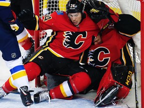 Calgary Flames Travis Hamonic is pushed into goaltender Mike Smith by the Scottie Upshall of the St. Louis Blues during NHL hockey at the Scotiabank Saddledome in Calgary on Monday, Nov. 13, 2017.