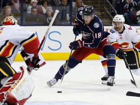 Columbus Blue Jackets forward Pierre-Luc Dubois looks for an open shot as the Calgary Flames' TJ Brodie defends during the second period of an NHL hockey game Wednesday, Nov. 22, 2017, in Columbus, Ohio.