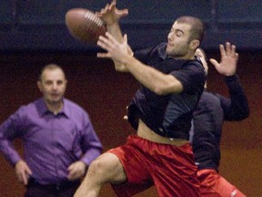 Under the watchful eyes of then-Flames head coach Brent Sutter, defenceman Mark Giordano catches a football during this 2009 file photo. Postmedia file photo