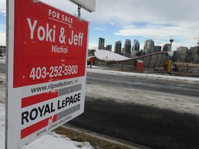 A for sale sign for a home on Salisbury St. in SE Calgary, Alta. frames the city skyline on Wednesday December 10, 2014. House prices in Calgary are beginning to fall however experts are advising homeowners not to sell. Stuart Dryden/Calgary Sun/QMI Agency