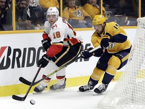 Calgary Flames center Matt Stajan (18) moves the puck ahead of Nashville Predators right wing Craig Smith (15) in the first period of an NHL hockey game Tuesday, Oct. 24, 2017, in Nashville, Tenn. (AP Photo/Mark Humphrey) ORG XMIT: TNMH114
