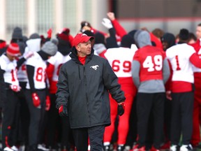 Stampeders head coach Dave Dickenson walks on the field with the team in the background in Calgary on Saturday, November 18, 2017 as they prepare for the CFL western final against the Edmonton Eskimos.