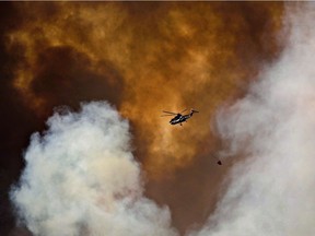 A helicopter battles a wildfire in Fort McMurray Alta, on Wednesday May 4, 2016.
