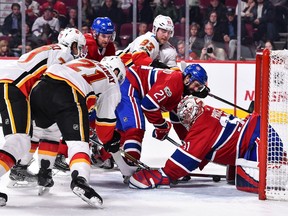 MONTREAL, QC - DECEMBER 07: Garnet Hathaway #21 of the Calgary Flames pokes the puck under goaltender Carey Price #31 of the Montreal Canadiens during the NHL game at the Bell Centre on December 7, 2017 in Montreal, Quebec, Canada. The Calgary Flames defeated the Montreal Canadiens 3-2 in overtime.