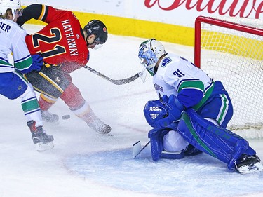 Vancouver Canucks goaltender Anders Nilsson watches the puck as Calgary Flames forward Garnet Hathaway looks to recover a rebound during NHL action in Calgary Saturday December 9, 2017.