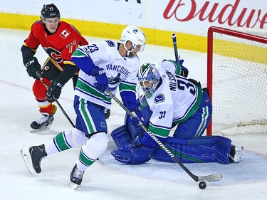 The Calgary Flames' Mark Jankowski watches as Vancouver Canucks defenceman Alexander Edler clears the puck in front of Vancouver Canucks goaltender Anders Nilsson during NHL action in Calgary Saturday December 9, 2017.