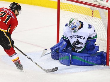 Vancouver Canucks goaltender Anders Nilsson stops this shot in front of the Calgary Flames' Garnett Hathaway during NHL action in Calgary Saturday December 9, 2017.