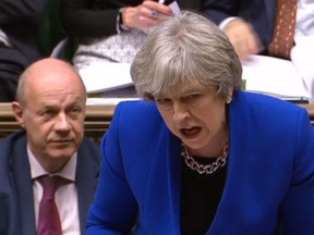 A video grab from footage broadcast by the UK Parliament's Parliamentary Recording Unit (PRU) shows Britain's Prime Minister Theresa May (R) gesturing as she speaks next to Britain's First Secretary of State Damian Green (L) on the front bench during the weekly Prime Ministers Questions (PMQs) session in the House of Commons in central London on Dec. 20, 2017. (AFP/Getty Images/HO)